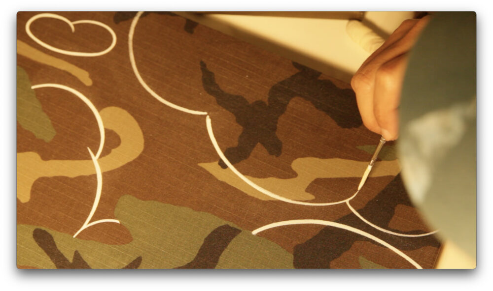 Close up canvas made by Camouflage Military clothes and outlined clouds are being drawn.