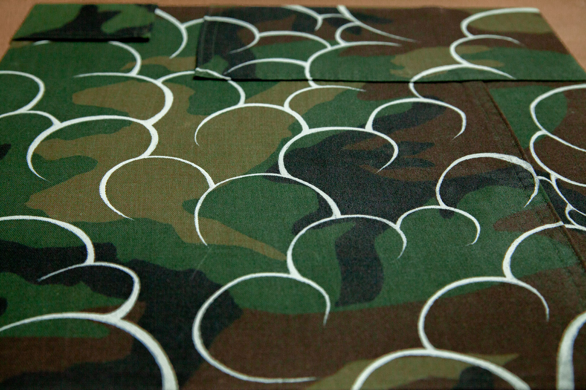 White outlined clouds filled over a woodland camouflage pattern